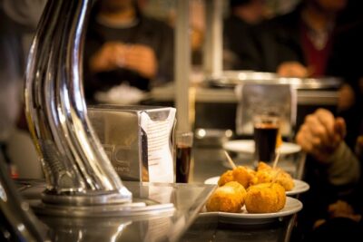 Madrid Local's Tapas Tour Dinner with a side of History - Puerta del Sol at night: the Time Square-style stories